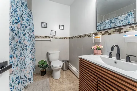 a bathroom with a sink toilet and a mirror
