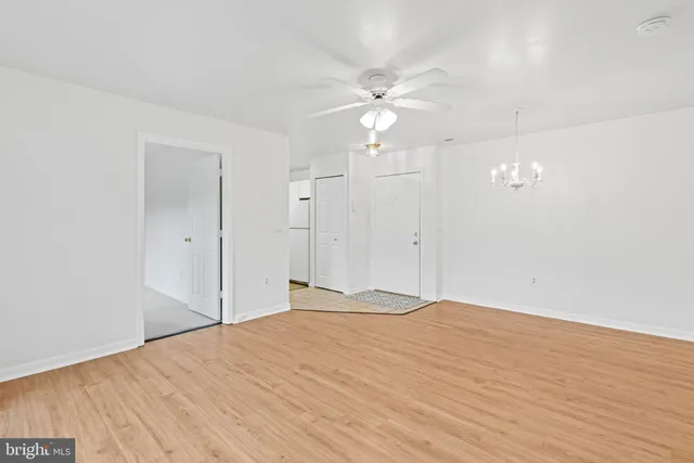 a view of a livingroom with a chandelier fan and windows