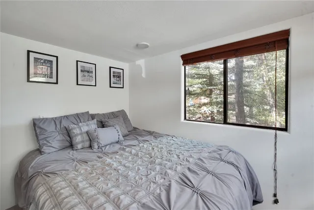 a large bed sitting in a bedroom next to a window