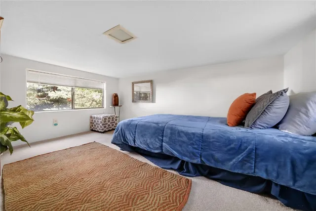 a bedroom with a bed and a dresser next to a window