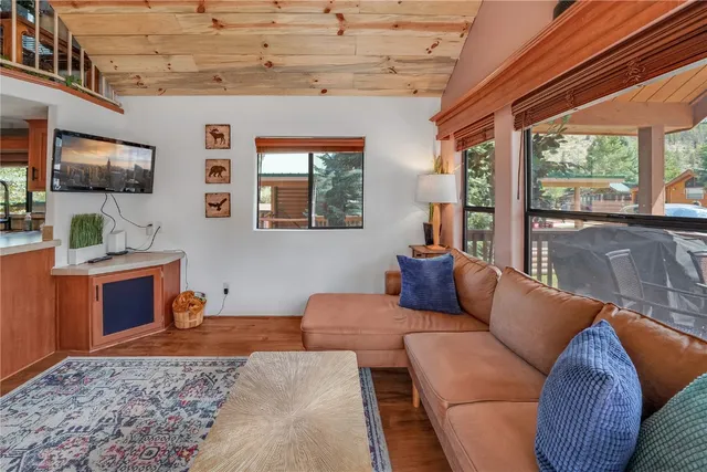 a living room with furniture a flat screen tv and windows