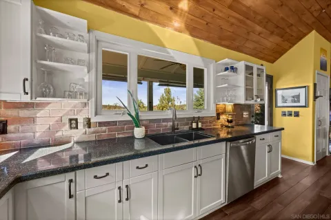 a kitchen with granite countertop a sink and a refrigerator