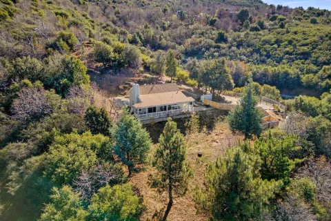 an aerial view of a house with a yard and lake view