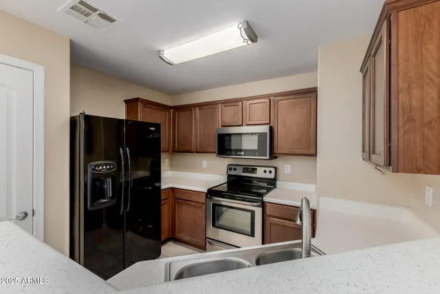 a kitchen with stainless steel appliances a refrigerator stove and microwave