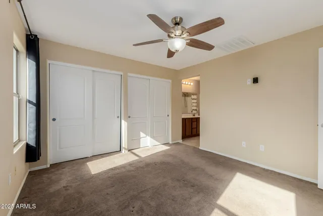 an empty room with closet and windows