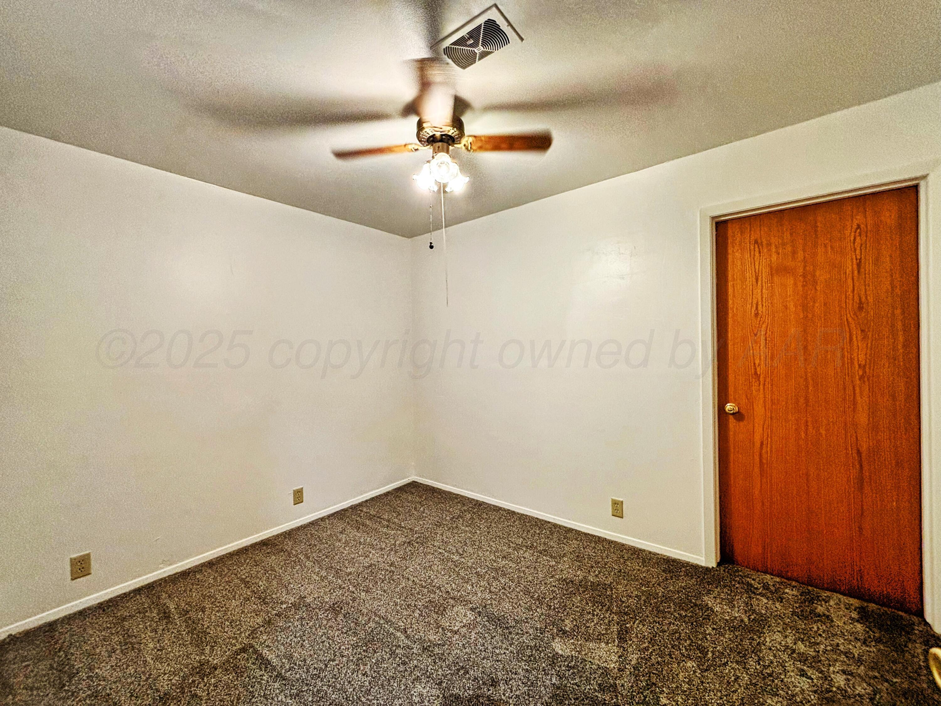 1510 South Indiana Street Perryton, TX 79070 - Photo 15 of 39 an empty room with a ceiling fan and carpet