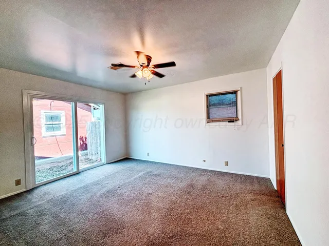 an empty room with closet and a chandelier fan