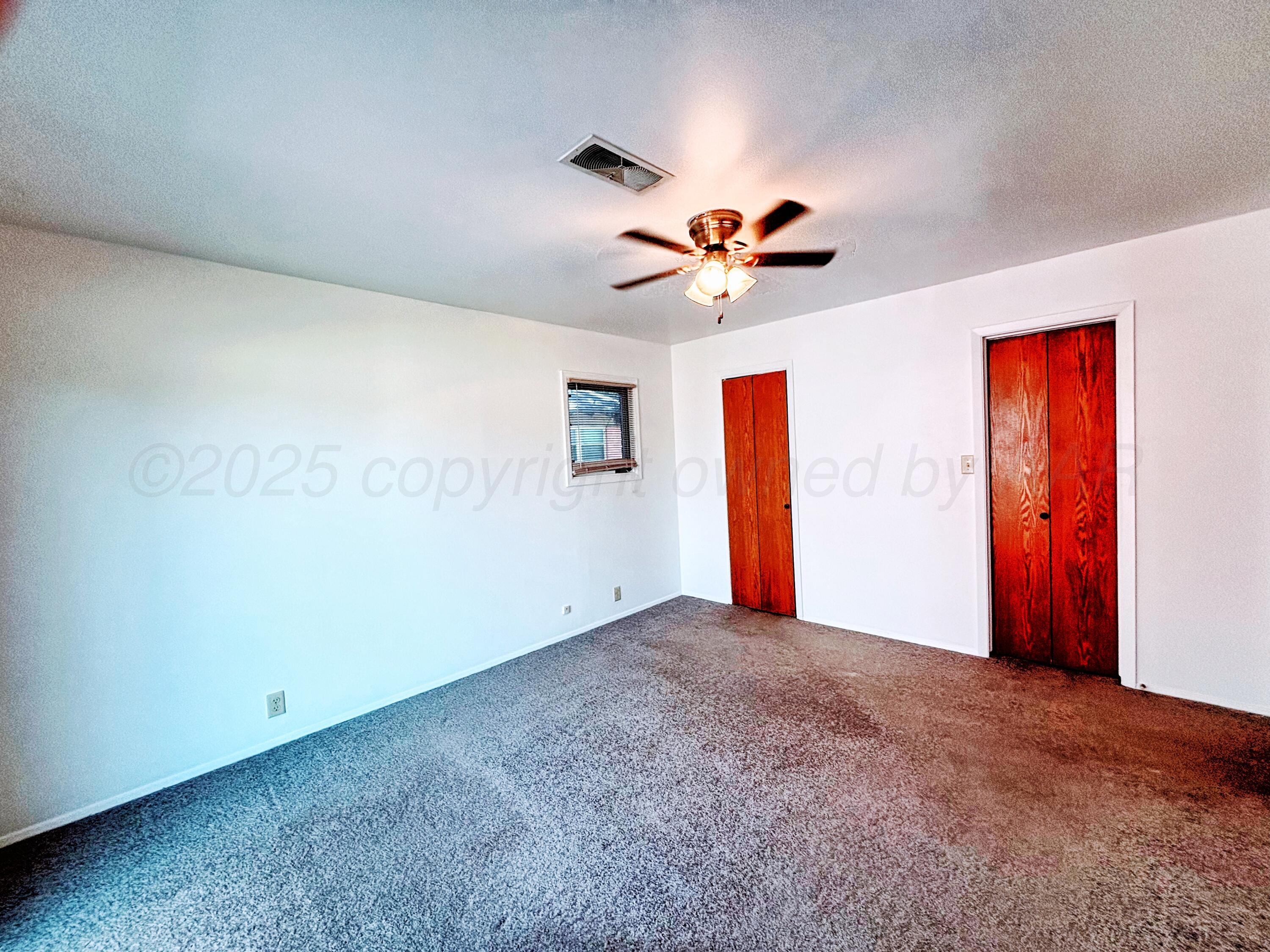1510 South Indiana Street Perryton, TX 79070 - Photo 18 of 39 an empty room with closet and a chandelier fan