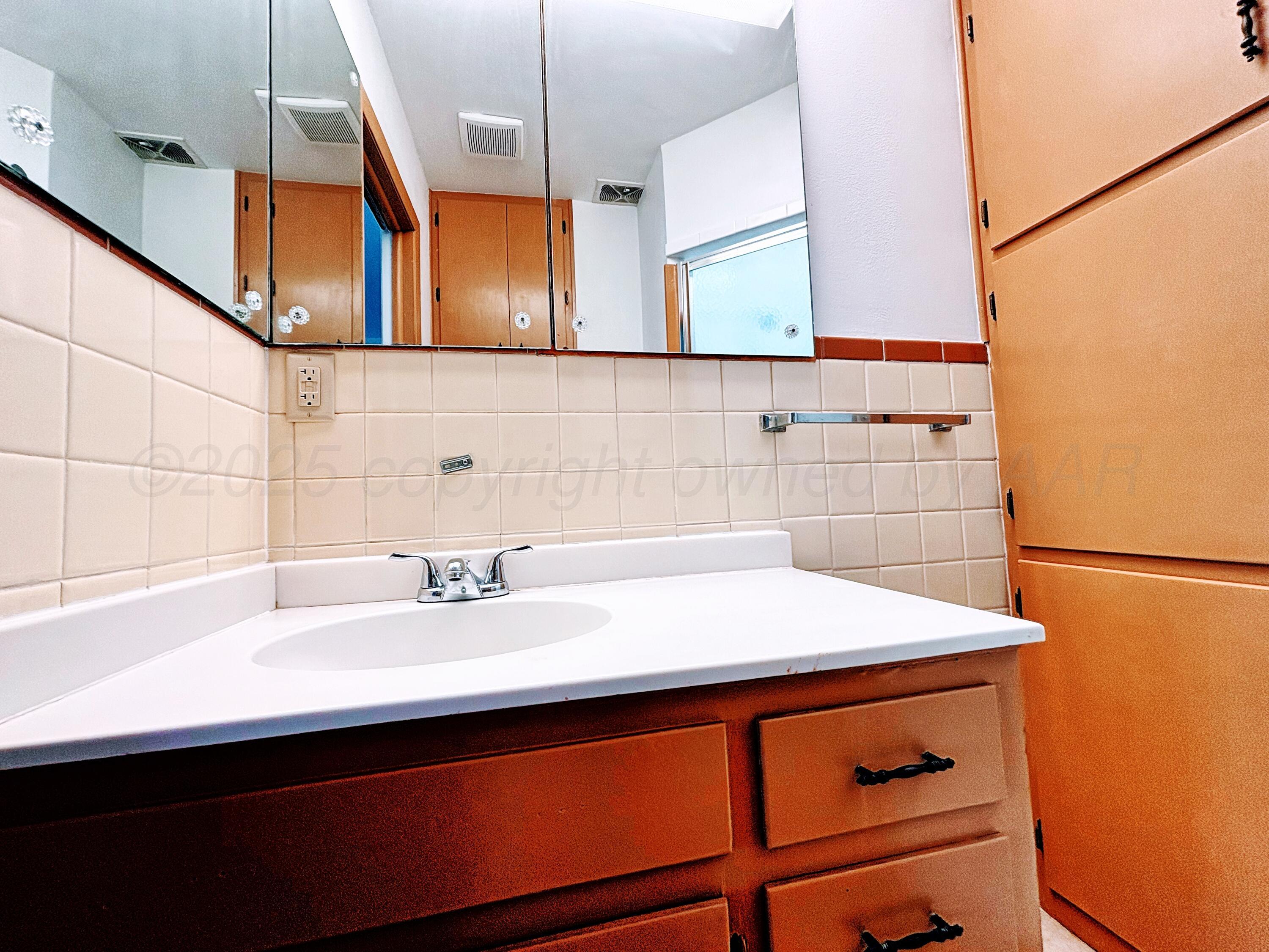 1510 South Indiana Street Perryton, TX 79070 - Photo 25 of 39 a bathroom with a sink and a mirror
