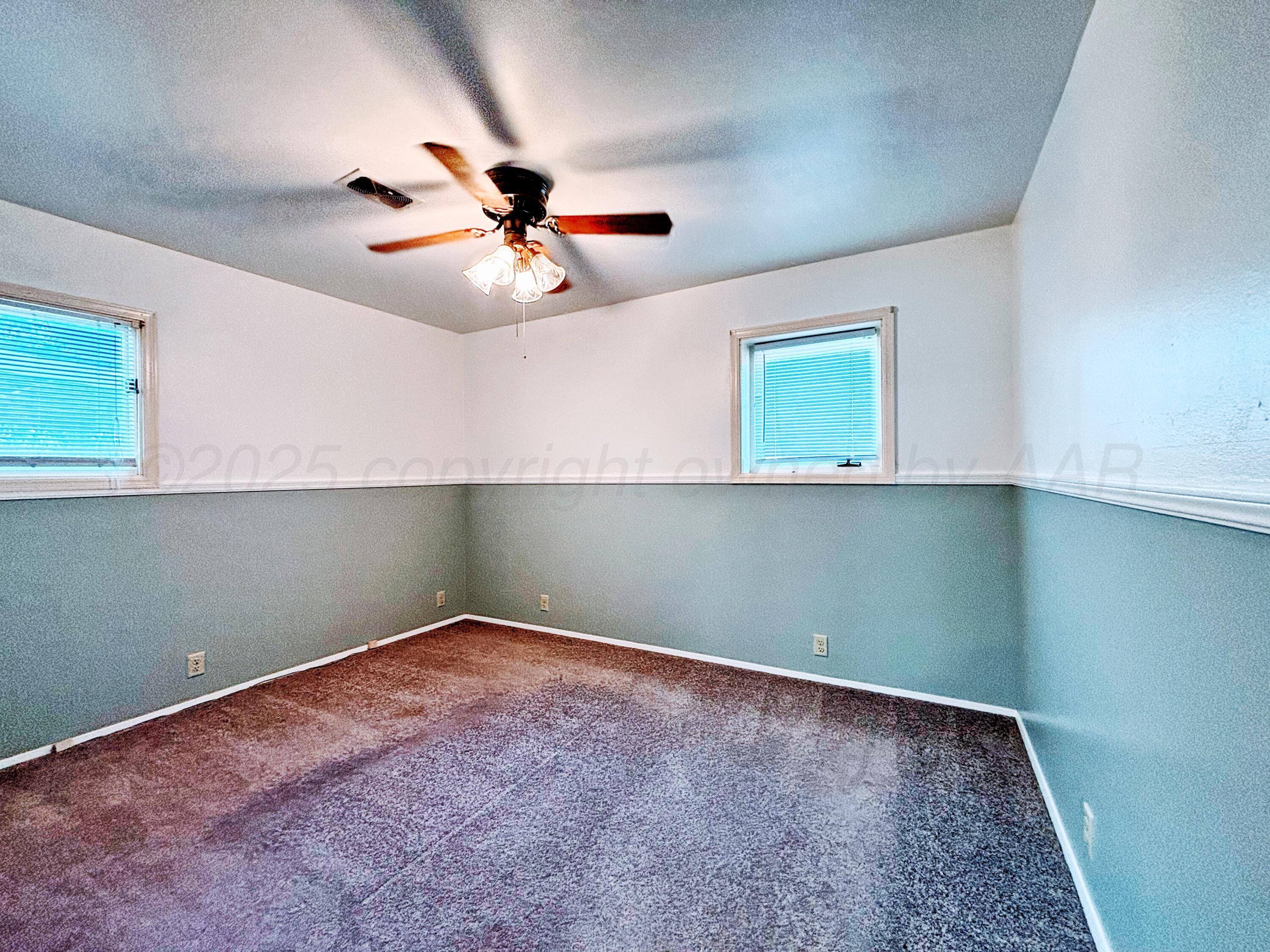 1510 South Indiana Street Perryton, TX 79070 - Photo 26 of 39 an empty room with windows and fan