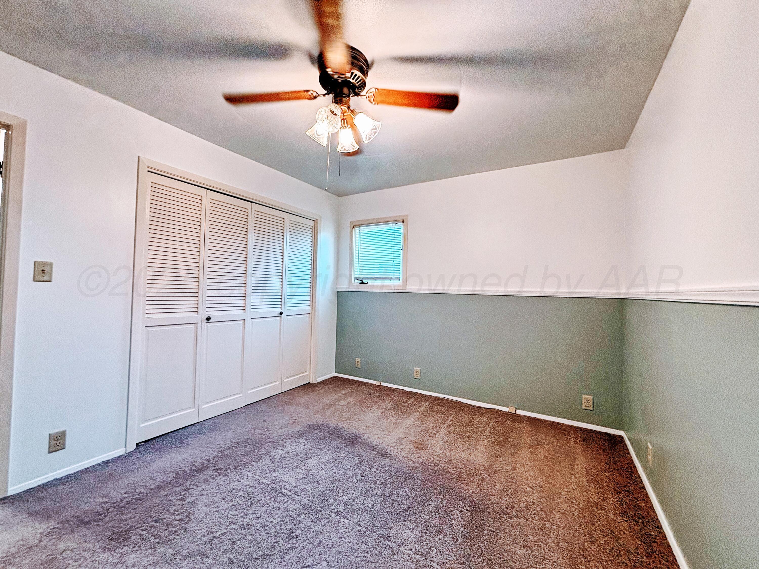 1510 South Indiana Street Perryton, TX 79070 - Photo 27 of 39 en empty room with windows and fan