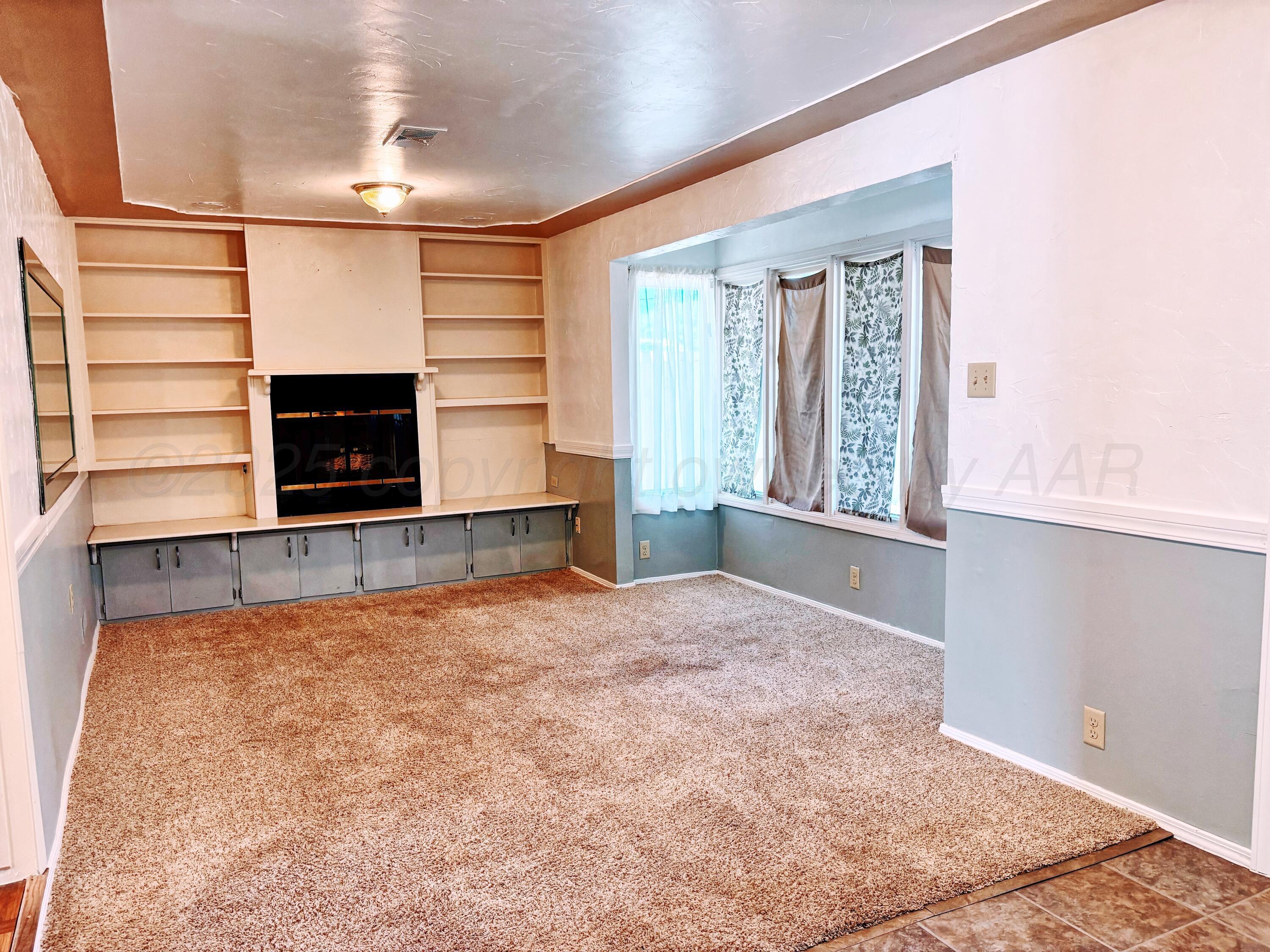 1510 South Indiana Street Perryton, TX 79070 - Photo 28 of 39 a view of an empty room with a fireplace and a window