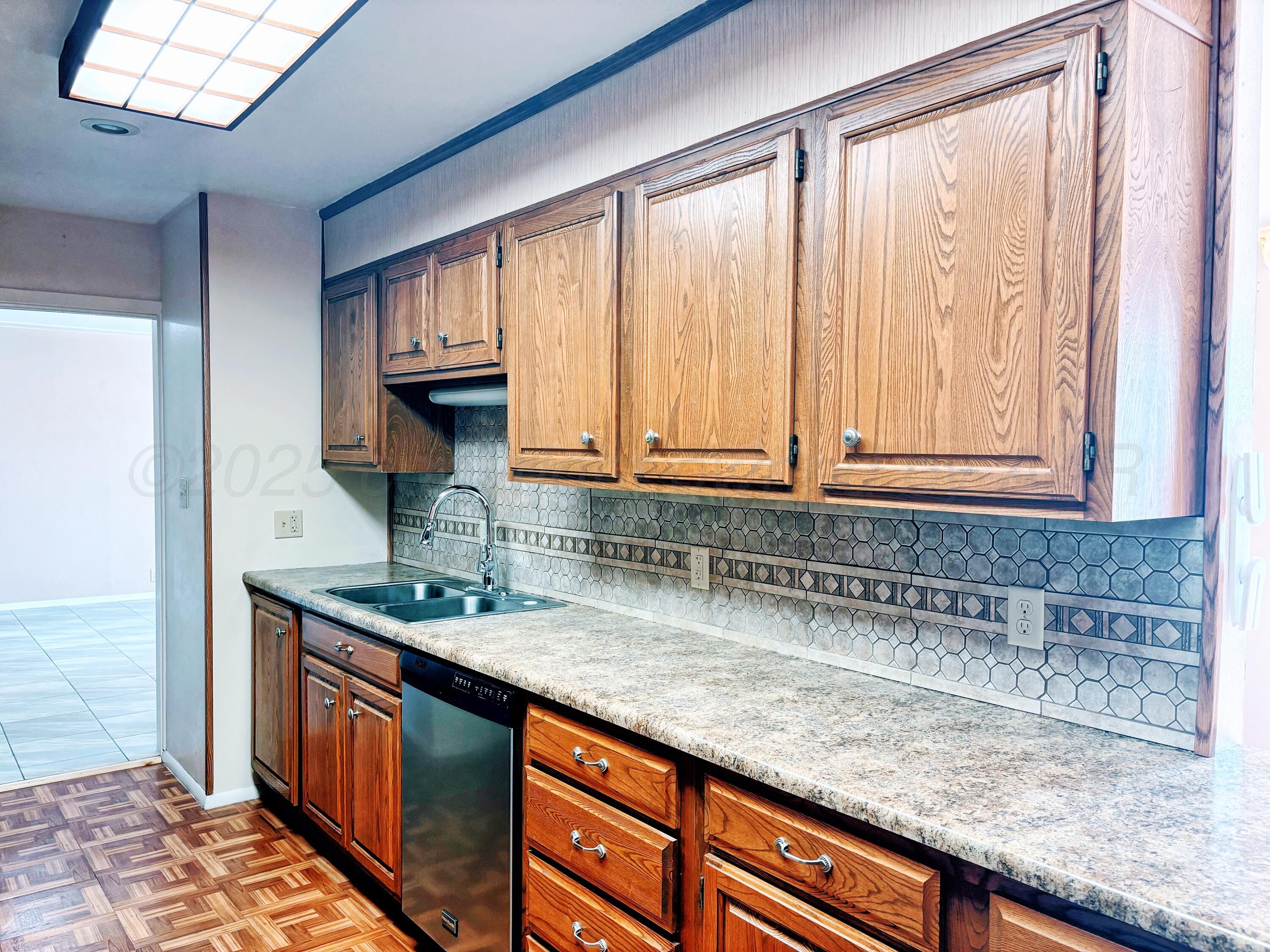 1510 South Indiana Street Perryton, TX 79070 - Photo 10 of 39 a kitchen with granite countertop a sink and a window