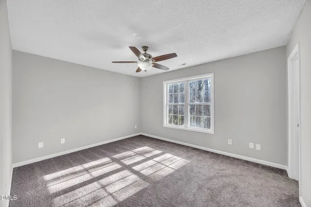 a view of wooden floor and a chandelier fan in a room