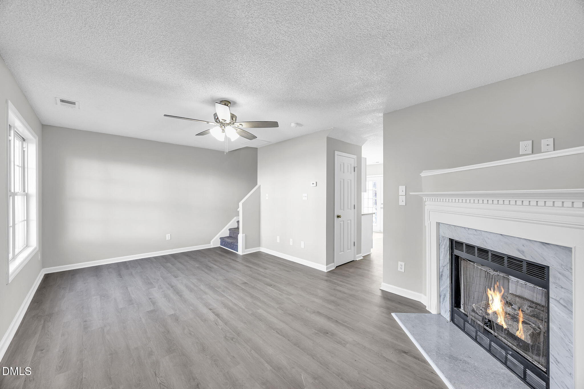 2231 Violet Bluff Court Raleigh, NC 27610 - Photo 2 of 16 a view of an empty room with wooden floor fireplace and a window
