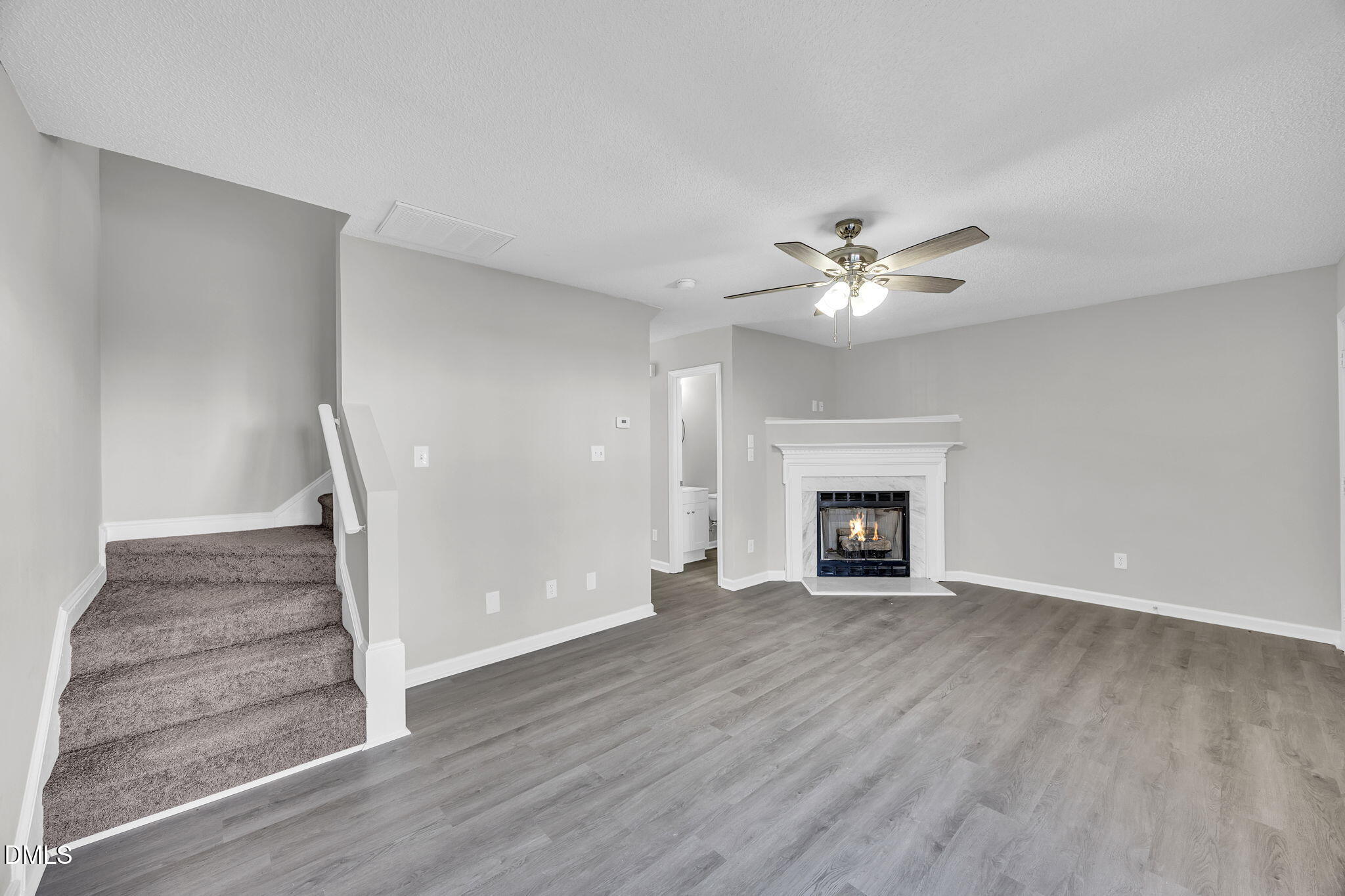 2231 Violet Bluff Court Raleigh, NC 27610 - Photo 3 of 16 a view of an empty room with wooden floor fireplace and a window