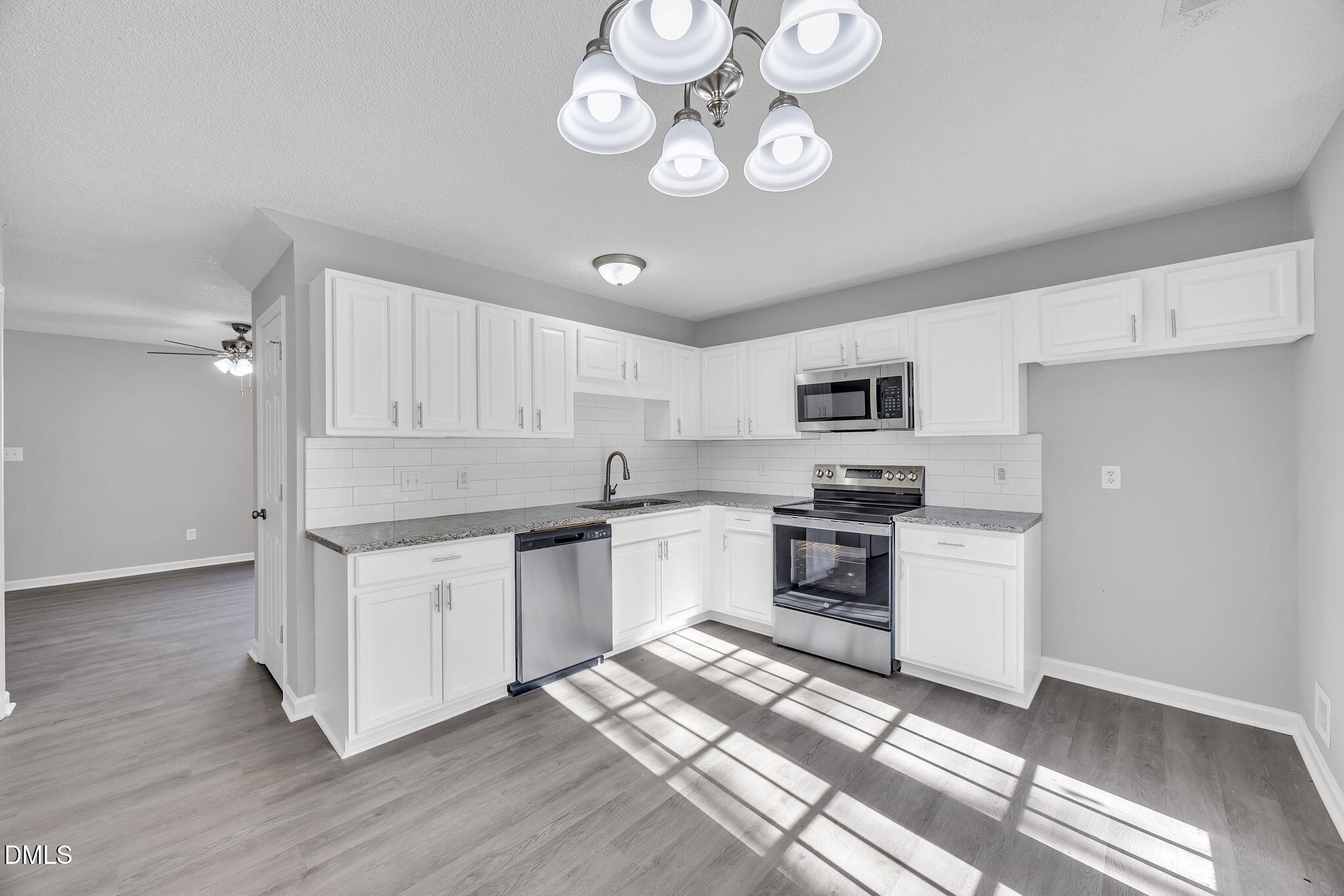 2231 Violet Bluff Court Raleigh, NC 27610 - Photo 7 of 16 a kitchen with stainless steel appliances granite countertop a stove top oven a sink dishwasher and a refrigerator with wooden floor