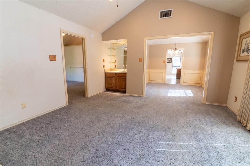 2028 Falcon Ridge Drive, Unit B Carrollton, TX 75010 - Photo 4 of 11 Carpeted empty room with suspended lighting, a wainscoted wall, and a decorative wall