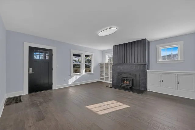 a view of an empty room with window and fire place