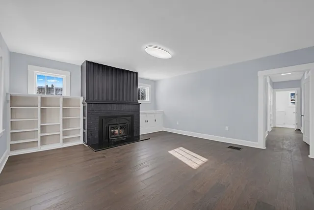 an empty room with a fireplace and window