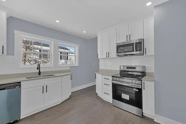a kitchen with stainless steel appliances a stove sink microwave and cabinets