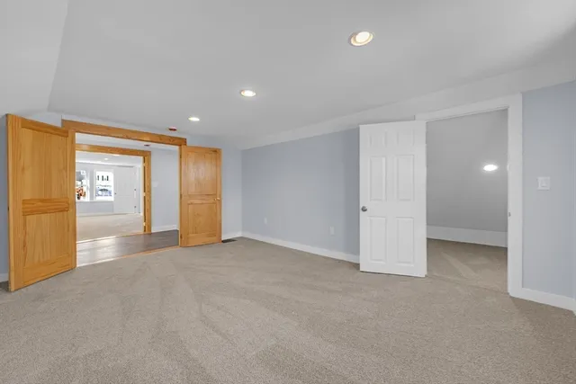 an empty room with a window and kitchen view