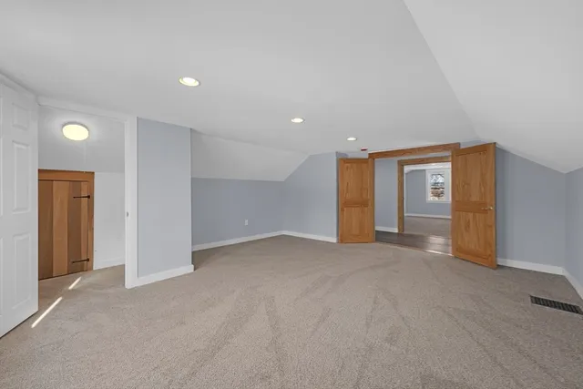 a view of an empty room with closet and window