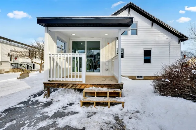 a balcony with table and chairs and potted plants