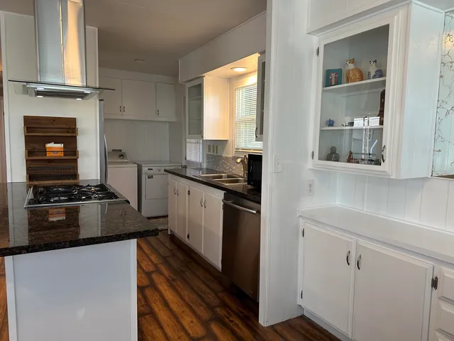 a kitchen with stainless steel appliances granite countertop a stove a sink and a refrigerator