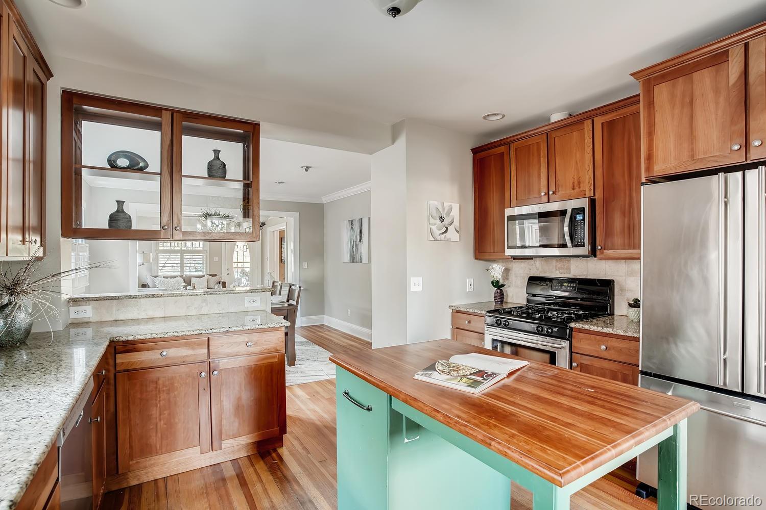 1028 Cook Street Denver, CO 80206 - Photo 12 of 40 a kitchen with stainless steel appliances granite countertop a stove refrigerator sink and cabinets
