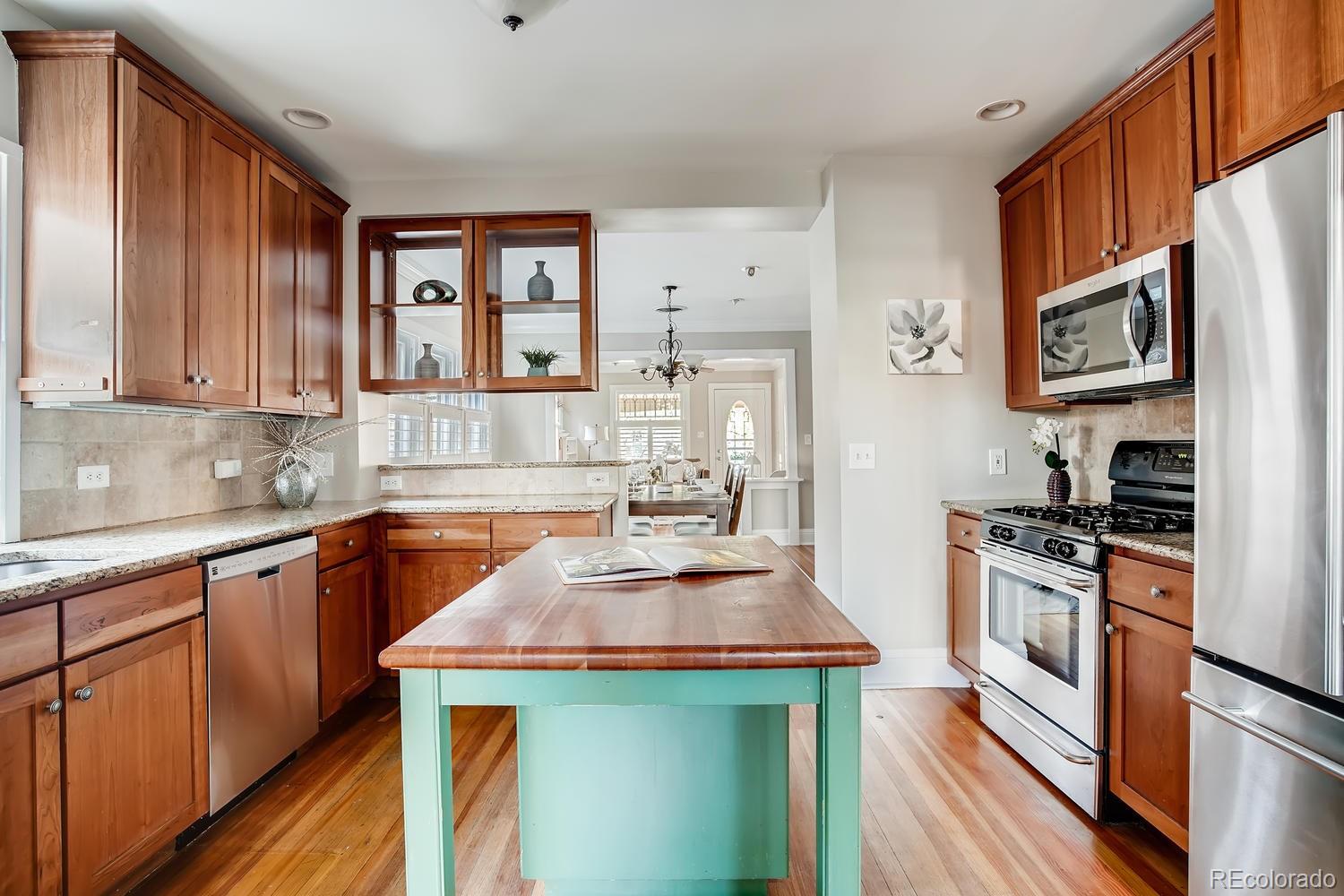 1028 Cook Street Denver, CO 80206 - Photo 14 of 40 a kitchen with stainless steel appliances granite countertop a stove a sink and a refrigerator