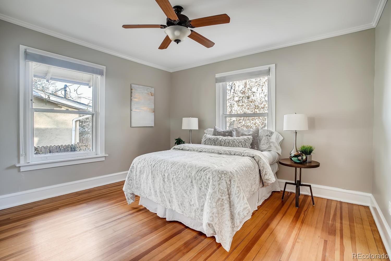1028 Cook Street Denver, CO 80206 - Photo 21 of 40 a bedroom with a bed windows and wooden floor