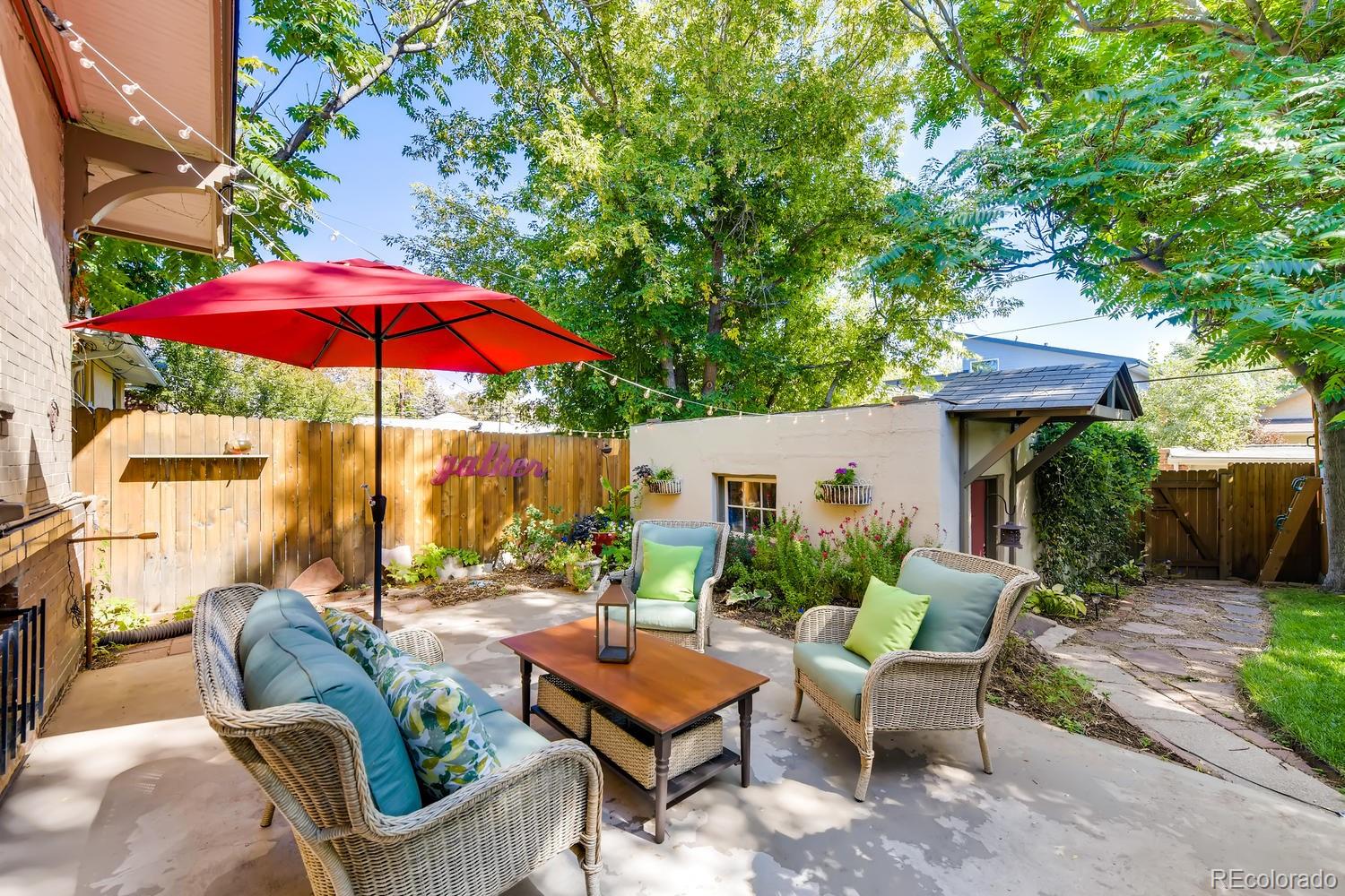 1028 Cook Street Denver, CO 80206 - Photo 29 of 40 a view of a patio with couches table and chairs under an umbrella with a barbeque