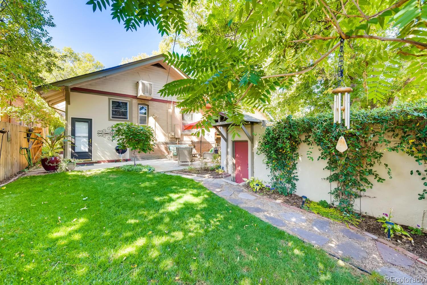 1028 Cook Street Denver, CO 80206 - Photo 32 of 40 a front view of a house with a yard and potted plants