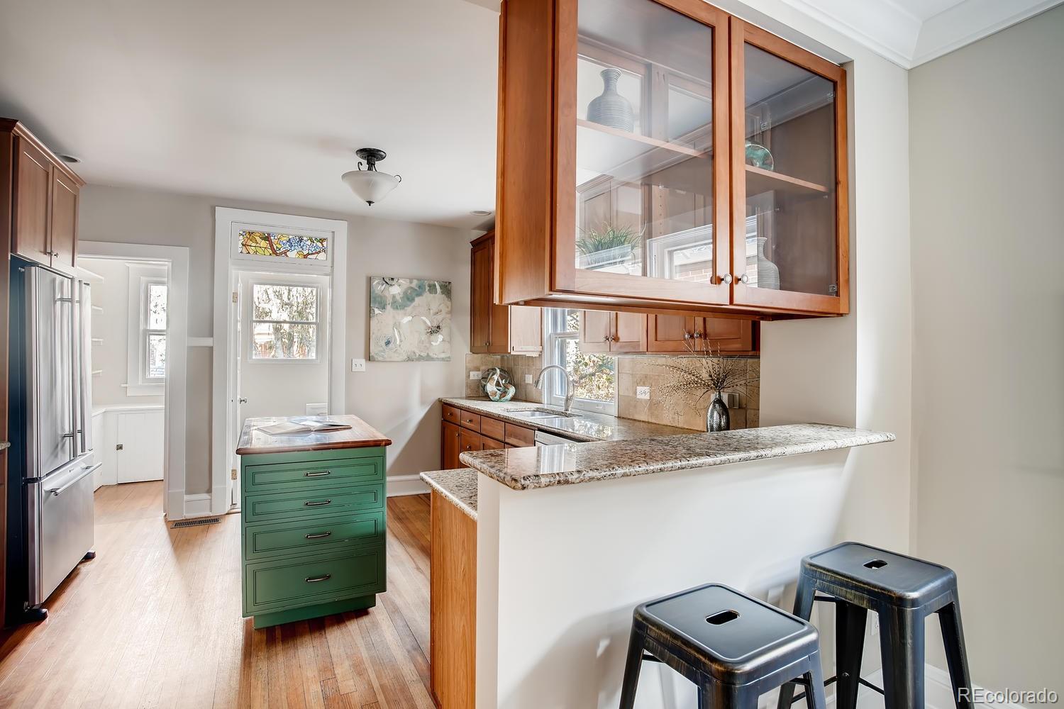 1028 Cook Street Denver, CO 80206 - Photo 9 of 40 a kitchen with granite countertop a sink cabinets and wooden floor