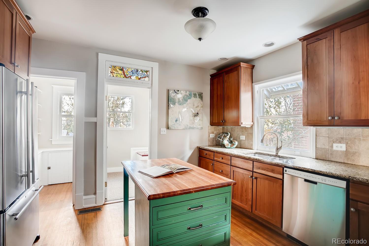 1028 Cook Street Denver, CO 80206 - Photo 10 of 40 a kitchen with stainless steel appliances granite countertop a sink stove and refrigerator
