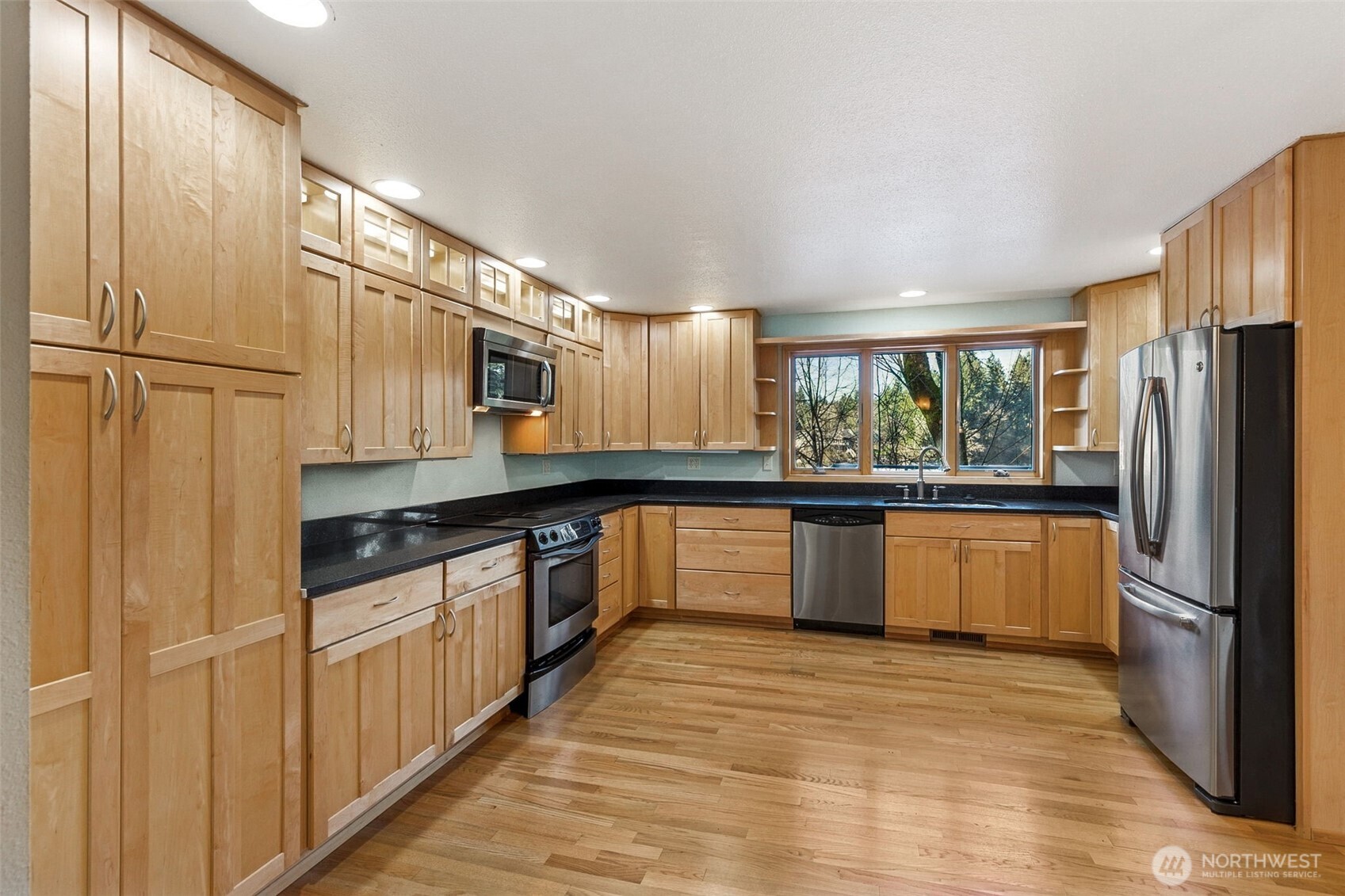 5221 Blvd Ext Road Southeast Olympia, WA 98501 - Photo 6 of 25 a large kitchen with granite countertop a refrigerator and a stove top oven