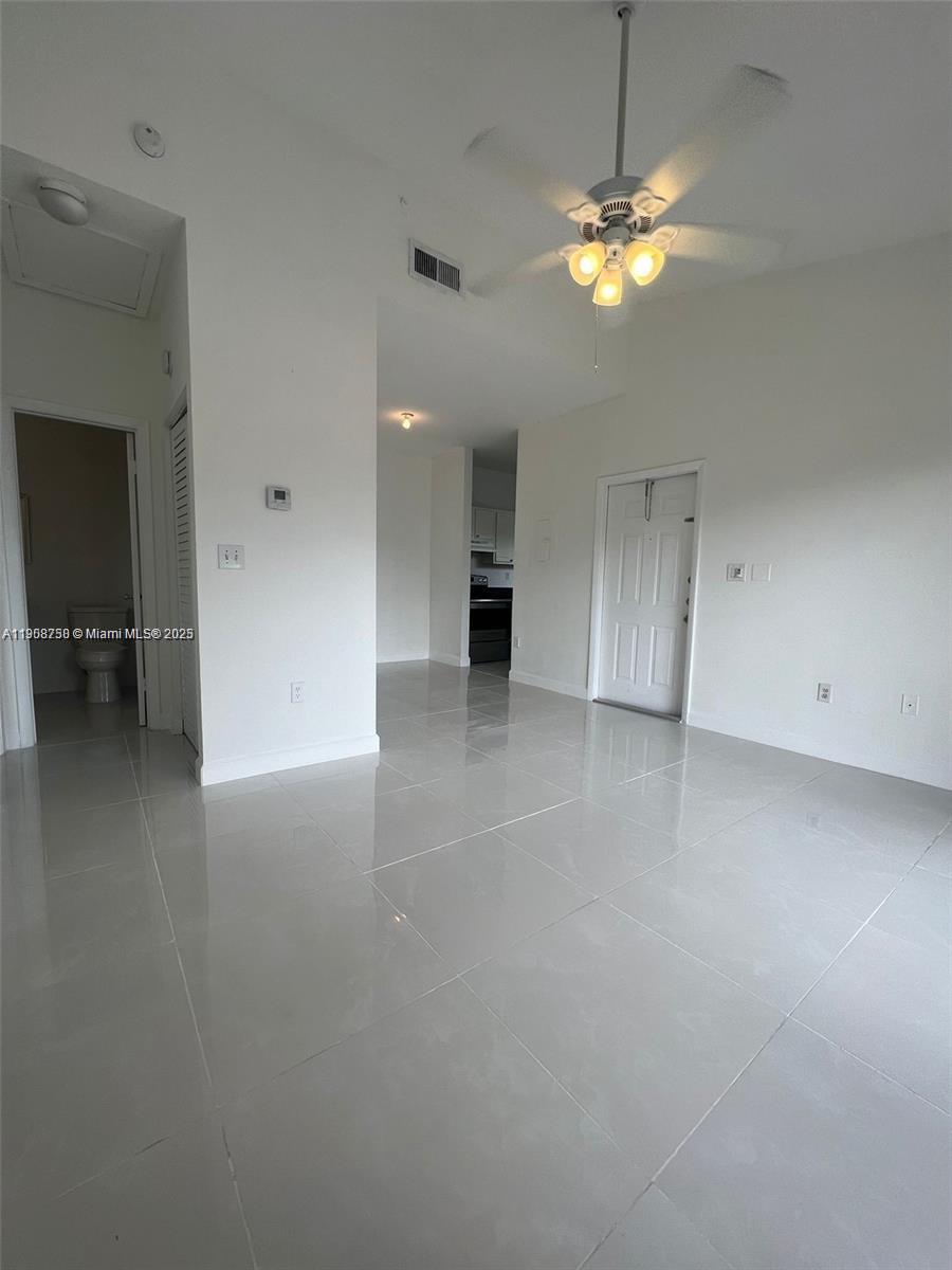 2001 Northwest 96th Terrace, Unit 10C Pembroke Pines, FL 33024 - Photo 1 of 10 an empty room with chandelier fan and windows