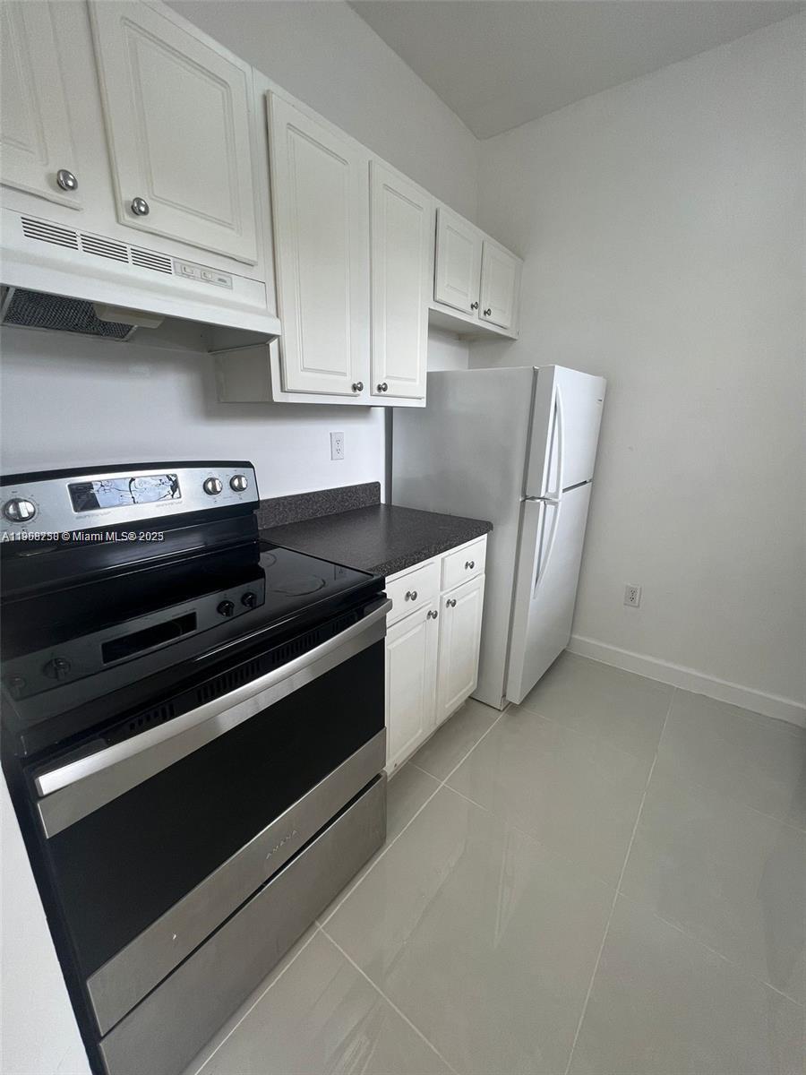 2001 Northwest 96th Terrace, Unit 10C Pembroke Pines, FL 33024 - Photo 3 of 10 a kitchen with stainless steel appliances a stove and white cabinets