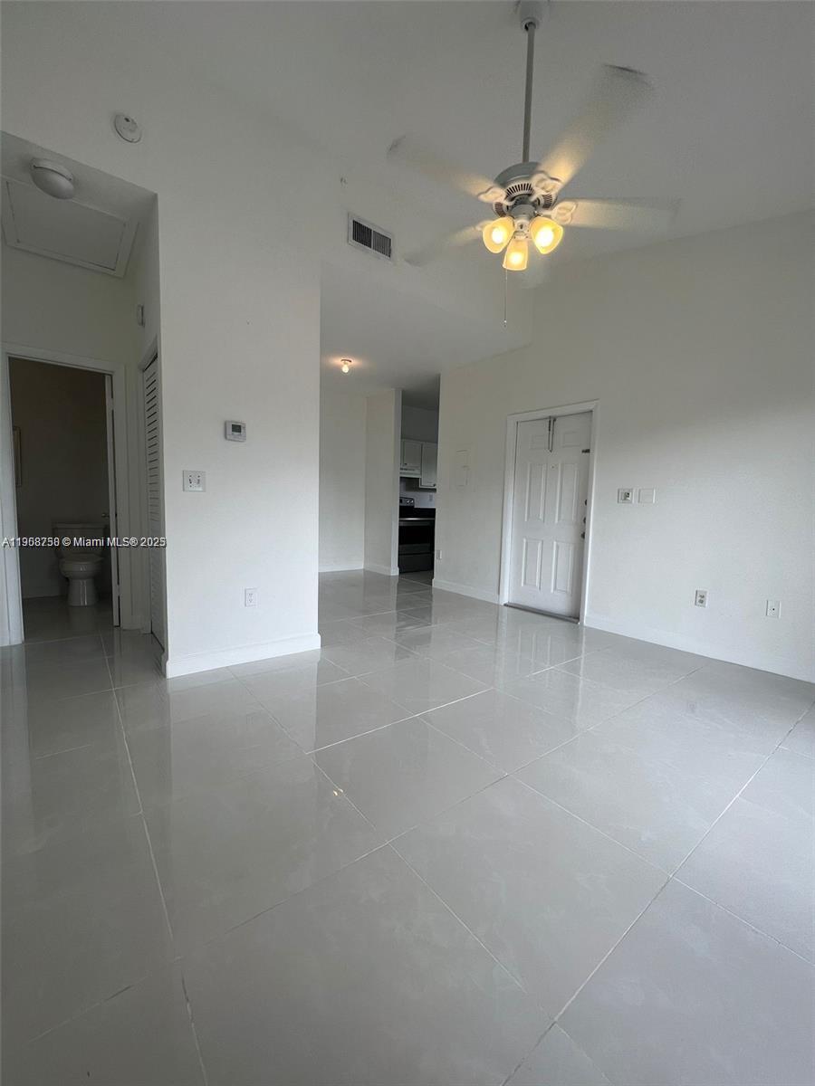 2001 Northwest 96th Terrace, Unit 10C Pembroke Pines, FL 33024 - Photo 4 of 10 wooden floor in an empty room with a chandelier fan