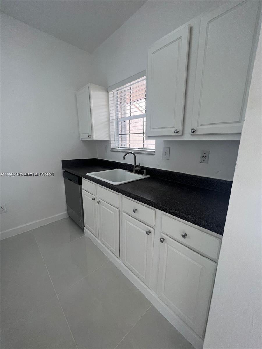 2001 Northwest 96th Terrace, Unit 10C Pembroke Pines, FL 33024 - Photo 5 of 10 a kitchen with granite countertop white cabinets and sink