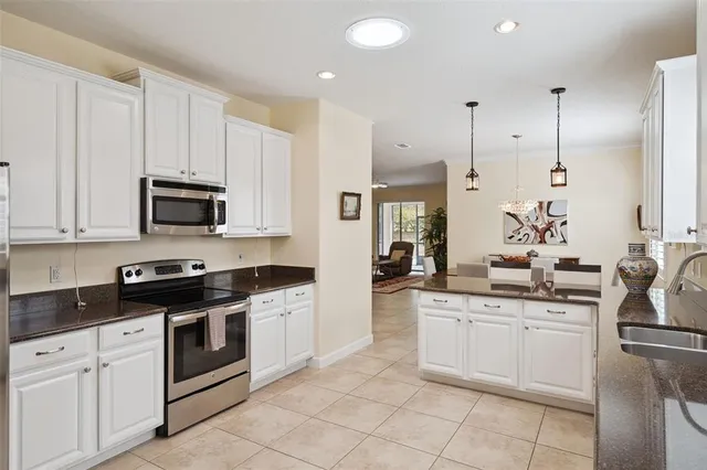 a kitchen with granite countertop white cabinets white stainless steel appliances with a sink and dishwasher