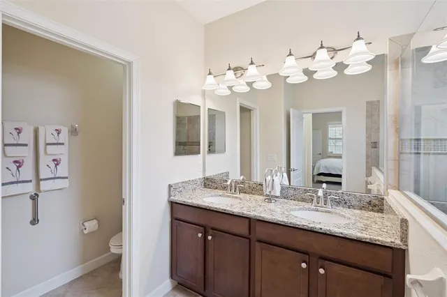 a bathroom with a granite countertop double vanity sink mirror and