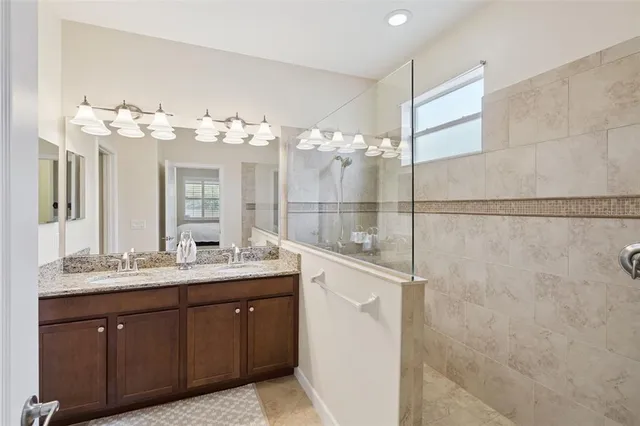 a spacious bathroom with a double vanity sink mirror and shower