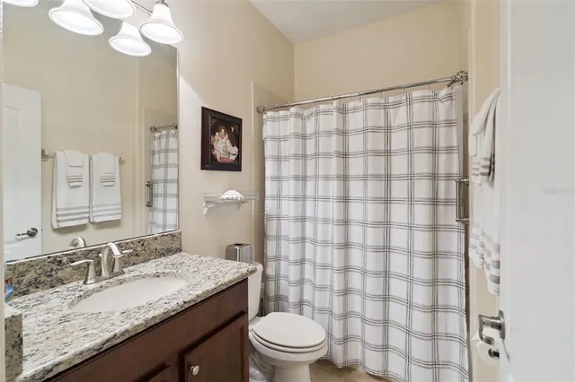 a bathroom with a granite countertop sink mirror vanity and toilet