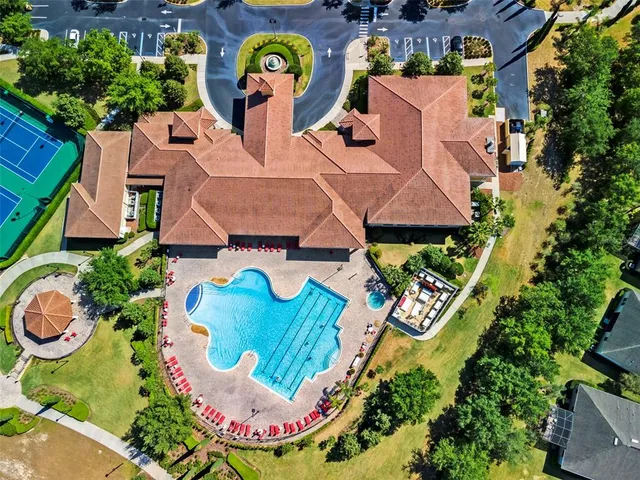 an aerial view of a house with swimming pool and outdoor seating