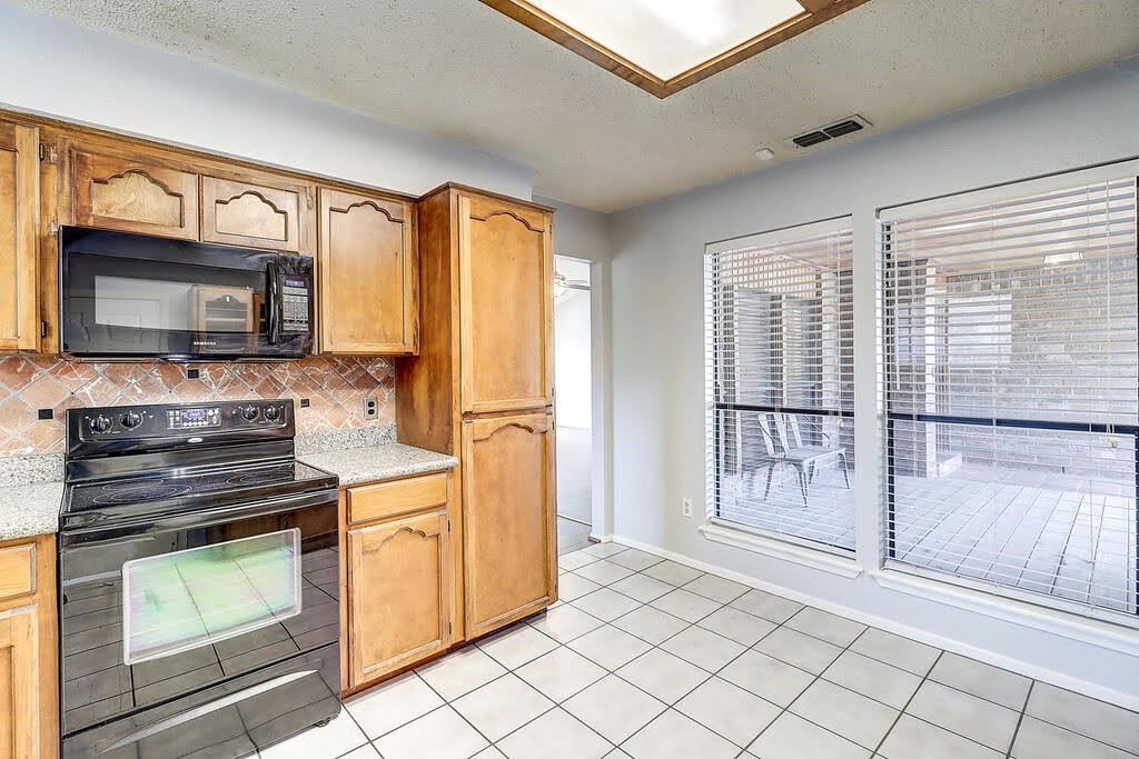 7034 Powderhorn Court Corpus Christi, TX 78413 - Photo 11 of 38 a kitchen with stainless steel appliances a stove sink and microwave