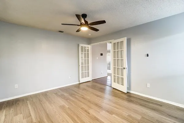 a view of empty room with wooden floor