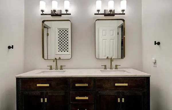 a bathroom with double vanity sinks and a mirror