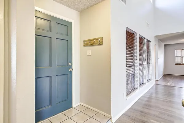 a view of a hallway with wooden floor and closet
